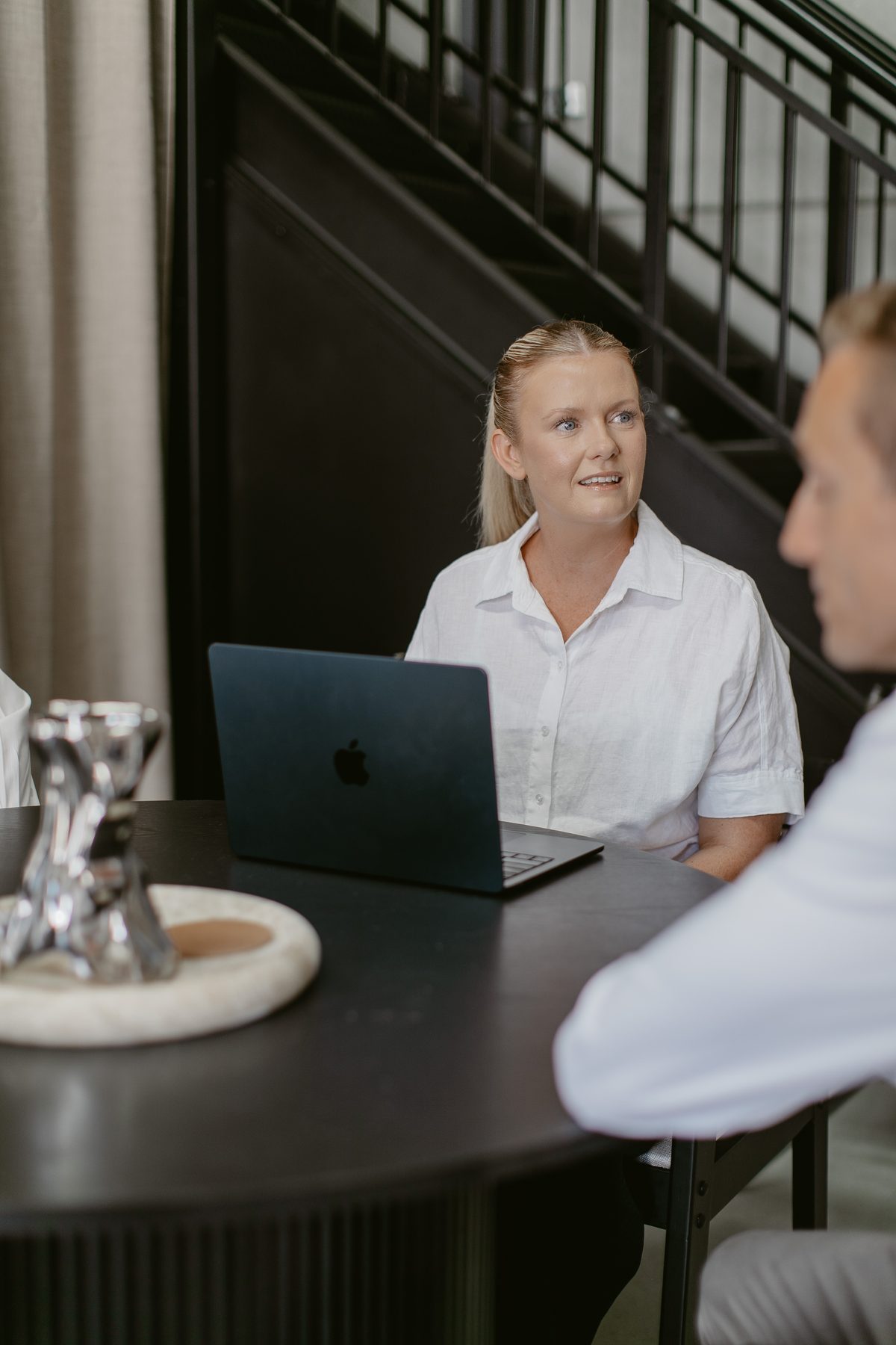 A Rapsey Griffiths practitioner at a meeting table with a laptop, two people seated opposite